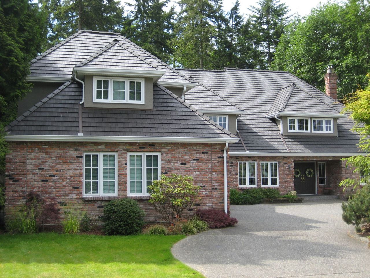 Euroshield Ranchlands Shake recycled rubber roof on a two-storey stone home