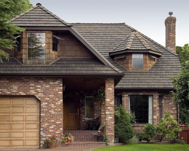 Euroshield Ranchlands Shake recycled rubber roof on a stone and stucco home